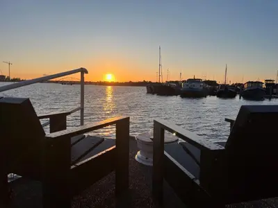 a sunset over a marina with boats in the water at Casey's Lake View House Boat in Amsterdam