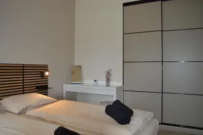 a bedroom with a bed and a dresser at Cozy bungalow (Near beach, tulip fields, etc) in Noordwijkerhout