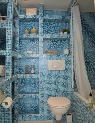 a blue tiled bathroom with a toilet and a shower at Cozy bungalow (Near beach, tulip fields, etc) in Noordwijkerhout
