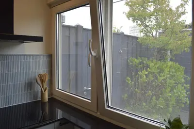 a window in a kitchen with a view of a garden at Cozy bungalow (Near beach, tulip fields, etc) in Noordwijkerhout