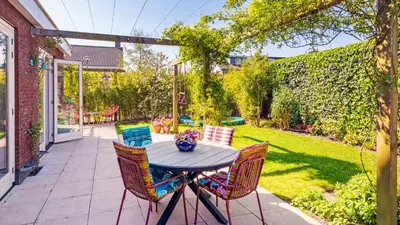 a patio with a table and chairs in a yard at Villa Boutique in Bergen