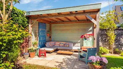 a pergola with a couch and chairs on a patio at Villa Boutique in Bergen