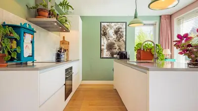a kitchen with green walls and white counter tops at Villa Boutique in Bergen