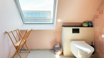 a bathroom with a toilet and a window at Villa Boutique in Bergen
