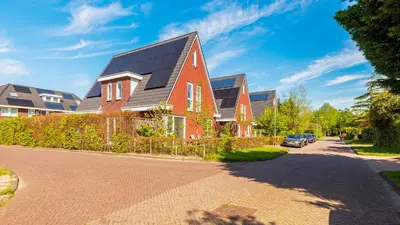 a red house with a black roof on a street at Villa Boutique in Bergen