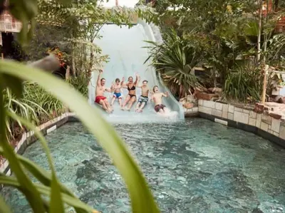 a group of boys sitting on a waterfall in a pool at Rode Tiny House met zwembad in Zeewolde