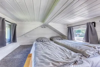 a bedroom with two beds in a tiny house at Rode Tiny House met zwembad in Zeewolde