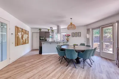 a kitchen and dining room with a table and chairs at Forest Villa with shared pool & Eco Wellness in Zeewolde
