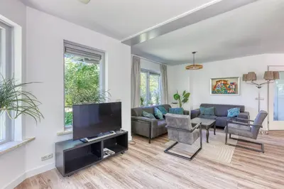 a living room with a large flat screen tv at Forest Villa with shared pool & Eco Wellness in Zeewolde