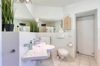 a white bathroom with a sink and a toilet at Forest Villa with shared pool & Eco Wellness in Zeewolde