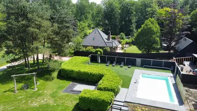 an aerial view of a yard with a swimming pool at Forest Villa with shared pool & Eco Wellness in Zeewolde