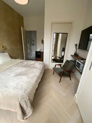 a bedroom with a large bed and a chair at Gorgeous room near Haarlem Station, city center in Haarlem