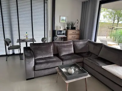 a living room with a leather couch and a table at Villa View in Alkmaar
