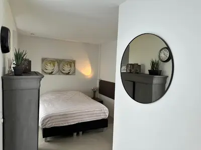 a bedroom with a bed and a round mirror at Villa View in Alkmaar