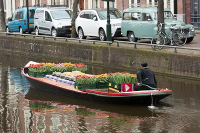 a man in a boat with flowers on the water at Villa View in Alkmaar