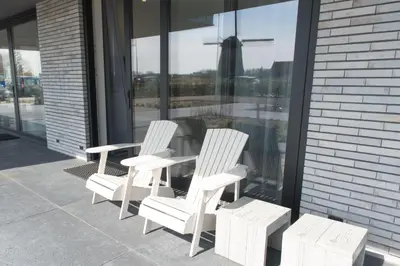 three white chairs and a table in front of a window at Villa View in Alkmaar