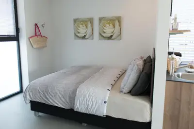a white bedroom with a bed and a sink at Villa View in Alkmaar