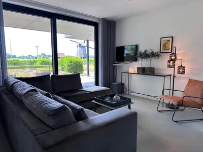 a living room with a couch and a tv at Villa View in Alkmaar