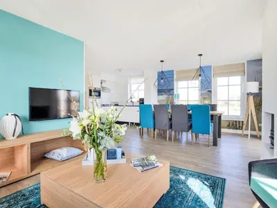 a living room with a vase of flowers on a table at Holiday Home Tapuit 6-1 by Interhome in Noordwijk