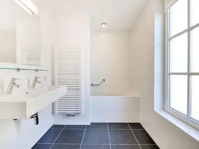 a white bathroom with a sink and a tub at Holiday Home Tapuit 6-1 by Interhome in Noordwijk