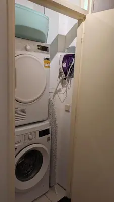 a laundry room with a washing machine and a washer at Kust Geluk in Schoorl