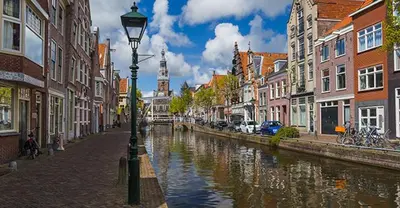 a river in a city with buildings and a street light at Kust Geluk in Schoorl