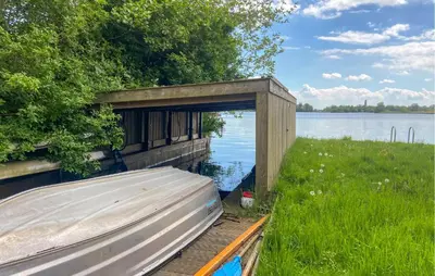 a small boat in a wooden structure next to a lake at Stunning Stacaravan In Reeuwijk in Reeuwijk