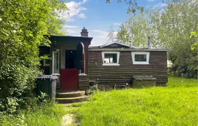 a small house with a red door in the grass at Stunning Stacaravan In Reeuwijk in Reeuwijk