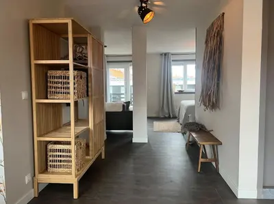 a room with a book shelf and a living room at Mint aan het strand in Egmond aan Zee