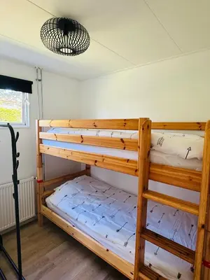 a bedroom with two bunk beds in a room at Familie Vakantiehuis - Zonneweelde in Noordwijk aan Zee