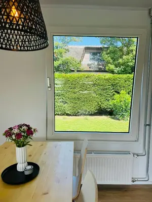a window in a room with a table and a vase of flowers at Familie Vakantiehuis - Zonneweelde in Noordwijk aan Zee
