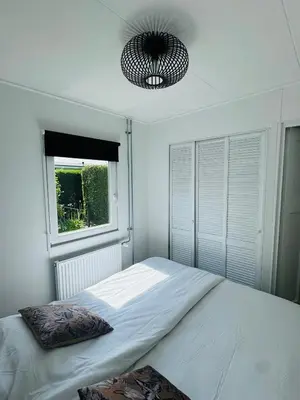 a bedroom with a large bed and a window at Familie Vakantiehuis - Zonneweelde in Noordwijk aan Zee