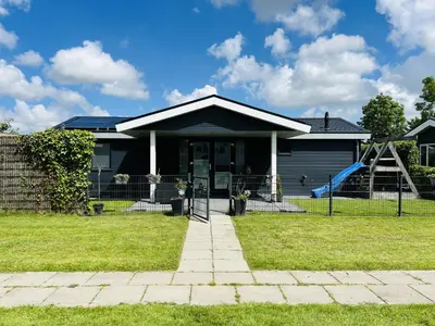a house with a playground in the yard at Bungalowpark de Horn - 821 in Dirkshorn