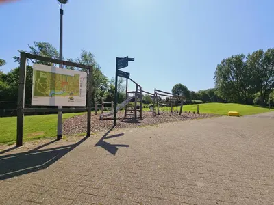 an empty park with a sign and a playground at Bungalowpark de Horn - 821 in Dirkshorn