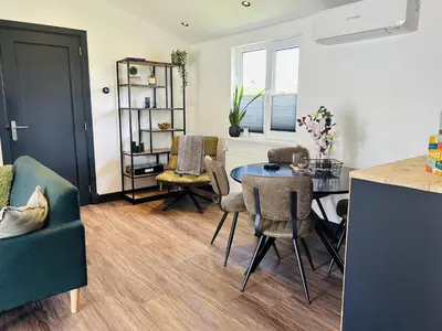 a kitchen and living room with a table and chairs at Bungalowpark de Horn - 821 in Dirkshorn