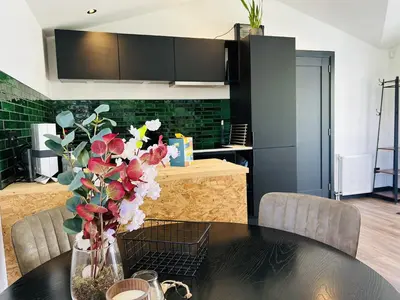 a kitchen with a table with a vase of flowers at Bungalowpark de Horn - 821 in Dirkshorn