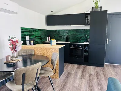 a kitchen with black cabinets and a table and chairs at Bungalowpark de Horn - 821 in Dirkshorn