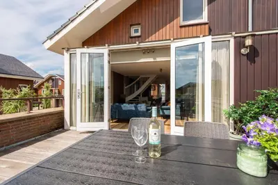 a bottle of wine on a table on a patio at Meerzicht 57 - 3 bedroom appt with sunny terrace in Uitgeest