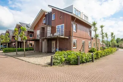 a building on a brick road next to a street at Meerzicht 57 - 3 bedroom appt with sunny terrace in Uitgeest