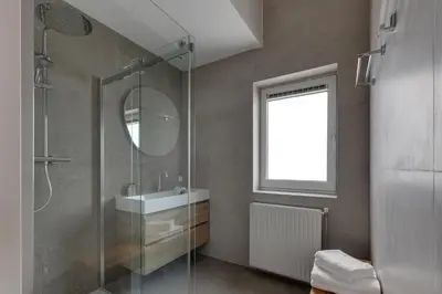 a bathroom with a shower and a sink and a mirror at Meerzicht 57 - 3 bedroom appt with sunny terrace in Uitgeest