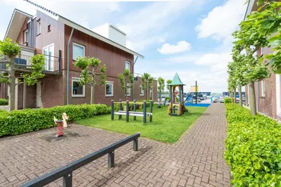 a child standing on a bench next to a playground at Meerzicht 57 - 3 bedroom appt with sunny terrace in Uitgeest
