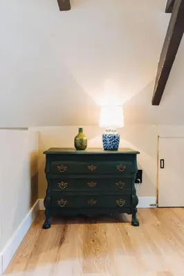 a green dresser with a lamp on top of it at Løk Historics luxury art-inspired loft in historic city centre! in Haarlem