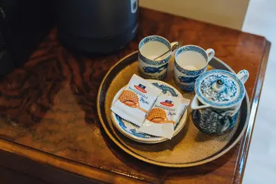 a table with a plate of food and cups on it at Løk Historics luxury art-inspired loft in historic city centre! in Haarlem