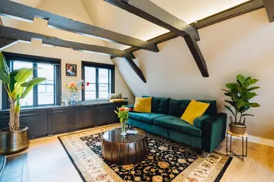 a living room with a green couch and a coffee table at Løk Historics luxury art-inspired loft in historic city centre! in Haarlem