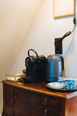 a slow cooker on top of a wooden dresser at Løk Historics luxury art-inspired loft in historic city centre! in Haarlem
