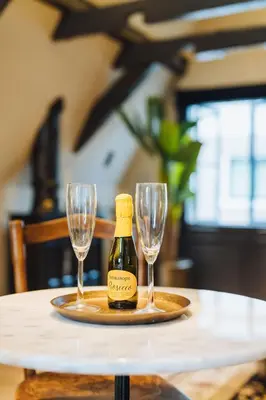 a bottle of wine and two glasses on a table at Løk Historics luxury art-inspired loft in historic city centre! in Haarlem
