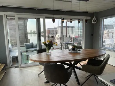 a dining room with a wooden table and chairs at Poellodge XL, houseboat met whirlpool en sauna in Aalsmeer