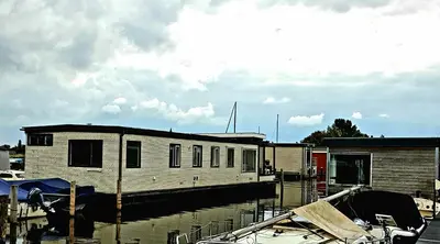 a house sitting on top of a marina at Poellodge XL, houseboat met whirlpool en sauna in Aalsmeer