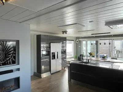 a kitchen with stainless steel appliances and a counter top at Poellodge XL, houseboat met whirlpool en sauna in Aalsmeer
