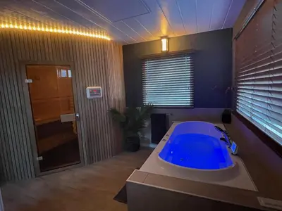 a bathroom with a blue tub in a room at Poellodge XL, houseboat met whirlpool en sauna in Aalsmeer